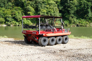 Red all-terrain vehicle on a gravel area with a body of water and trees in the background